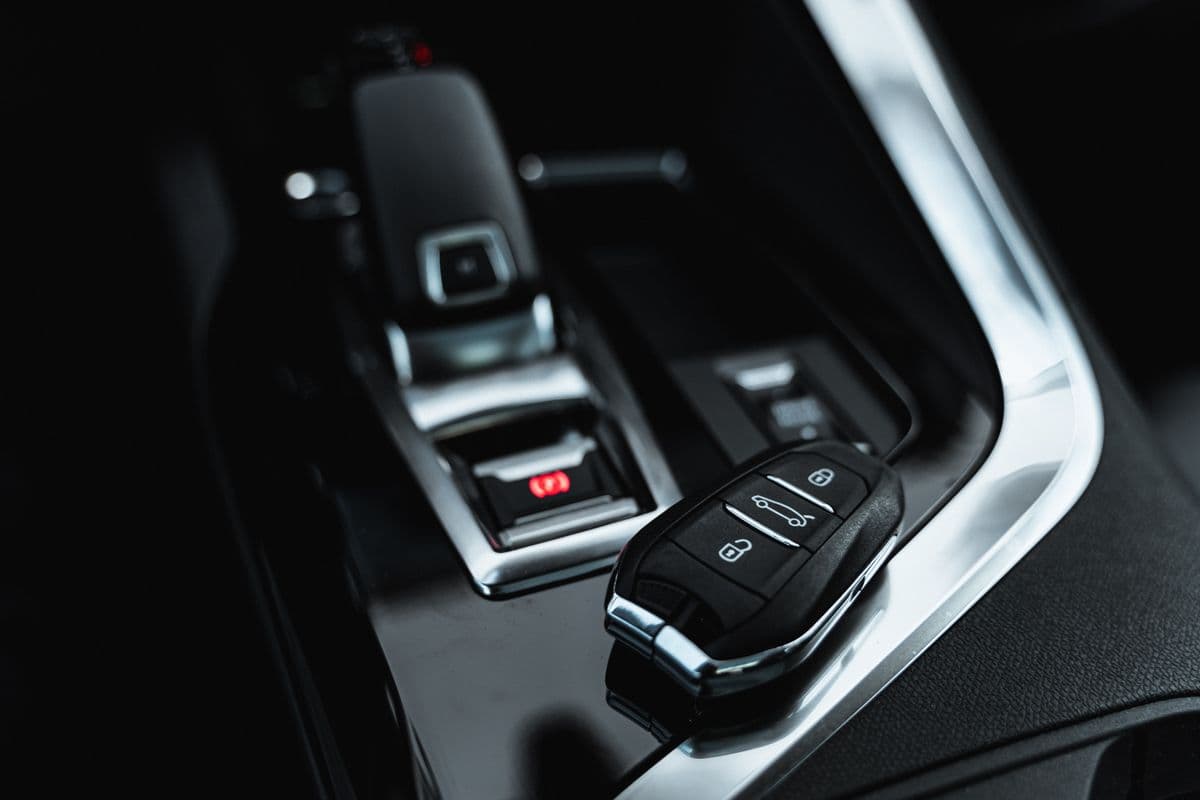 A car key resting on the centre console of a modern car