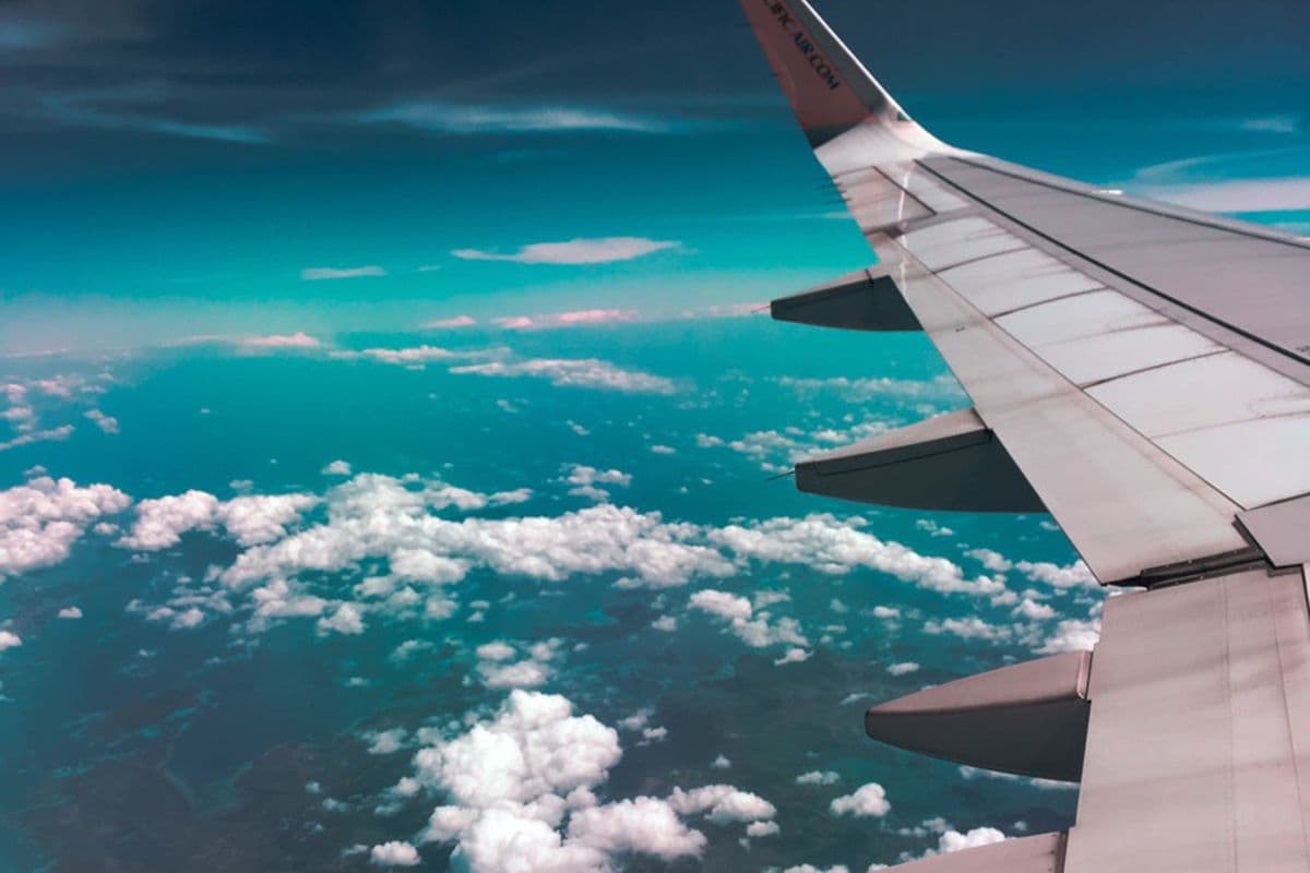 An aircraft wing above the clouds in flight